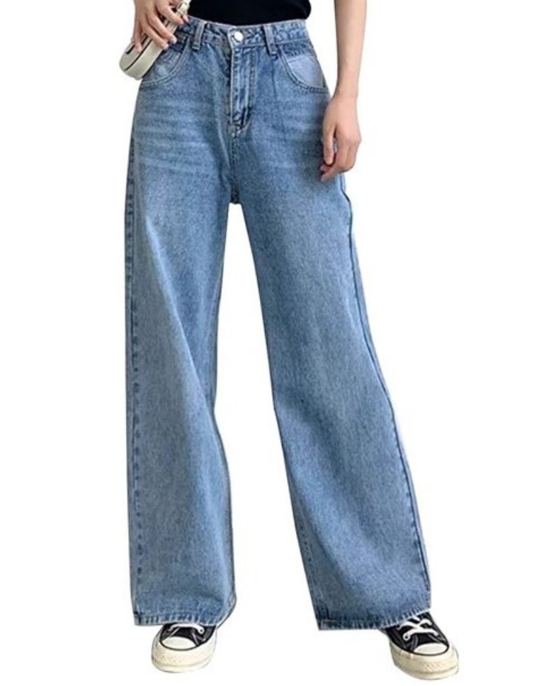 A model wearing a pair of light wash wide leg boyfriend jeans