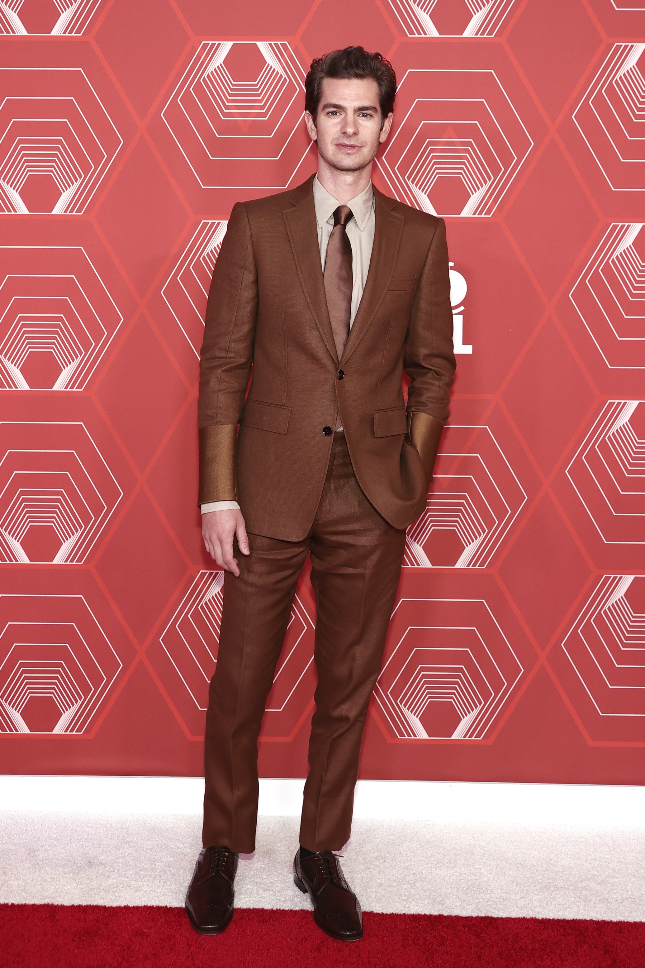 Andrew wears a brown suit with silk cuffs
