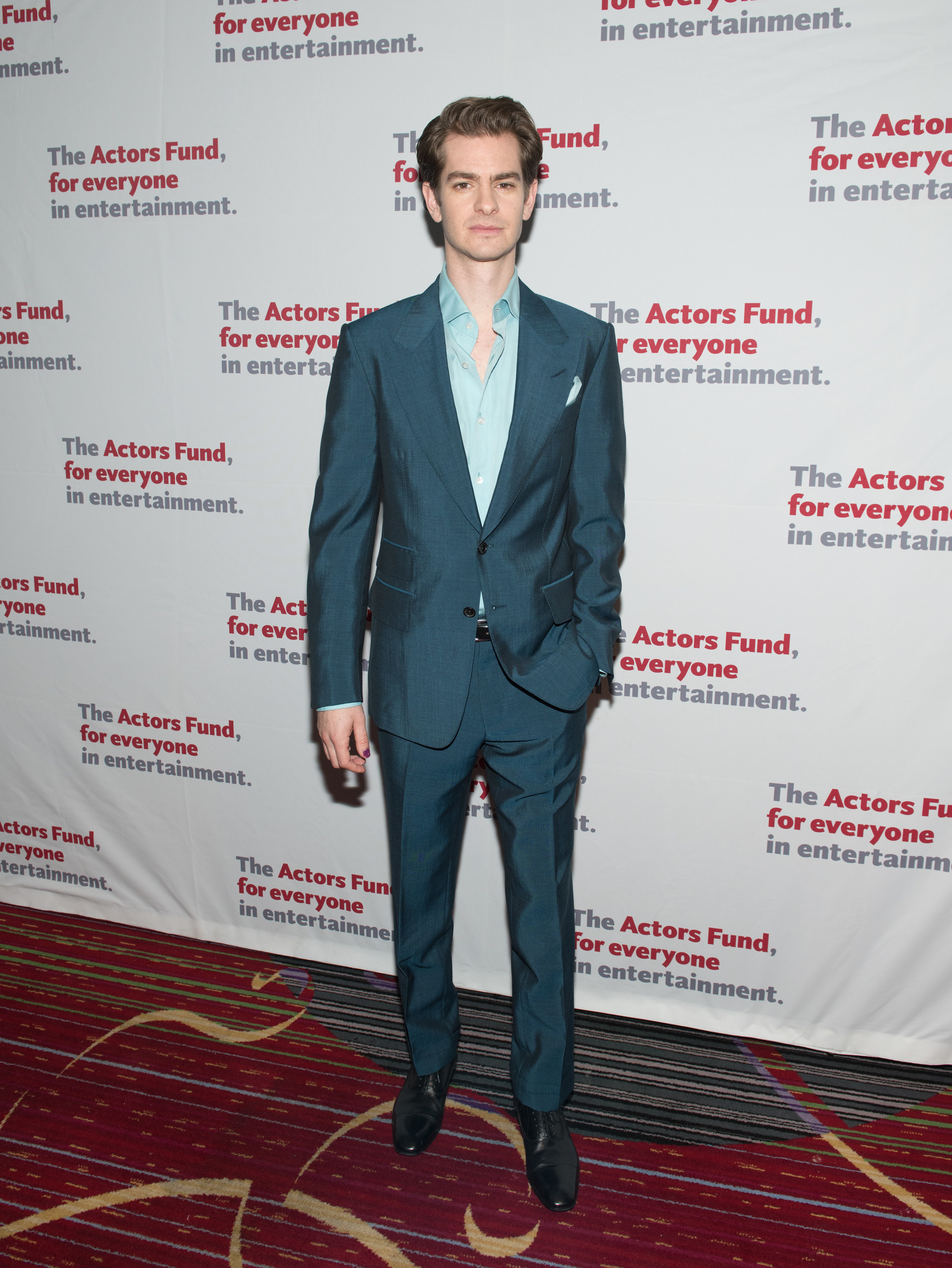 Andrew wears a turquoise suit and light blue shirt