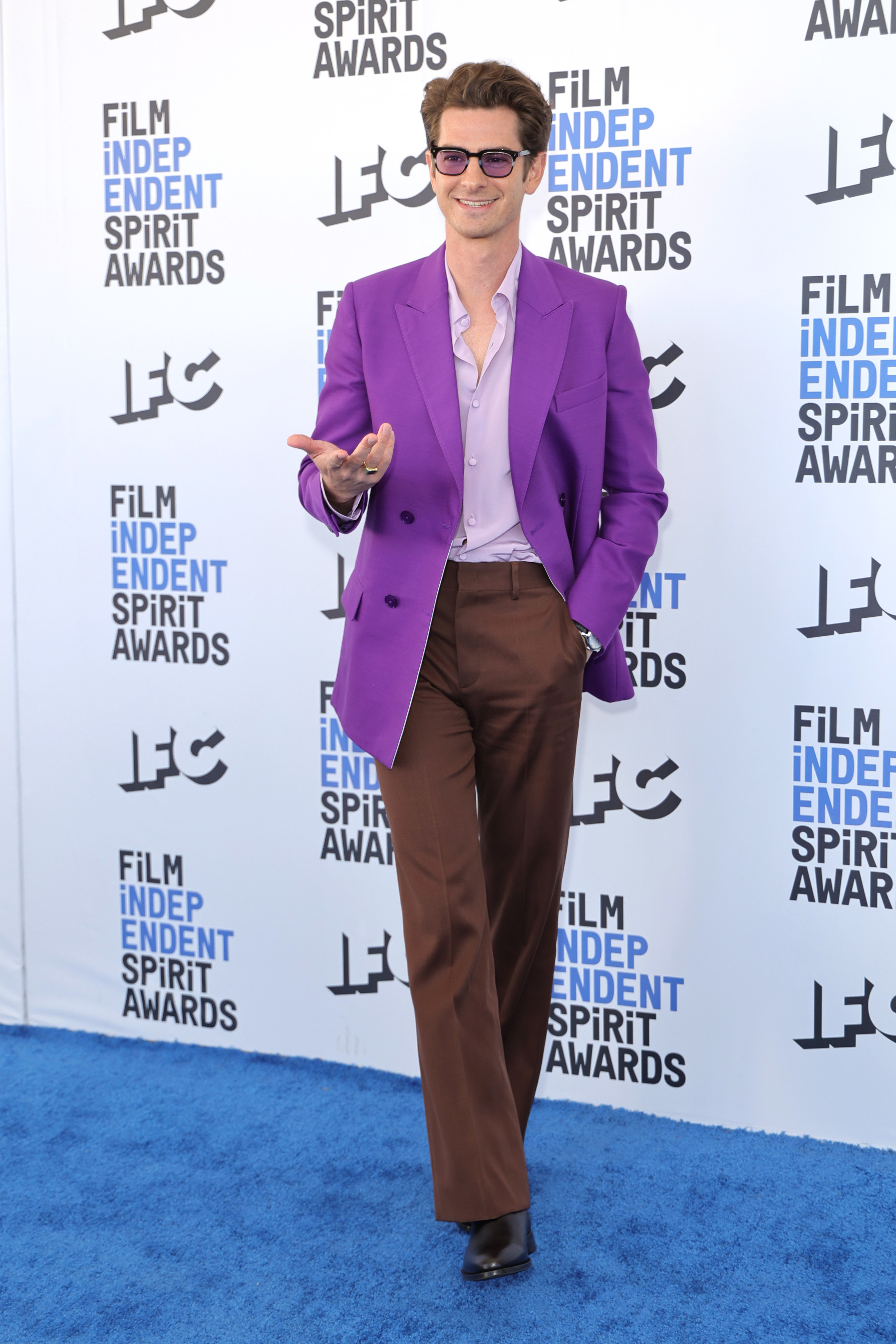 Andrew wears a purple blazer and brown flare pants