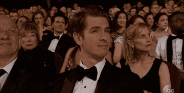 Andrew smiles while sitting in the audience of an award show