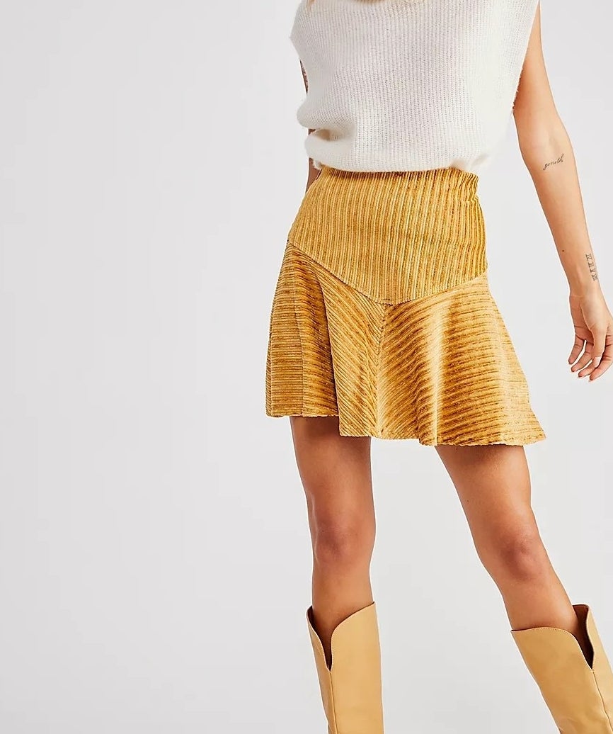 model wearing a white top and yellow mini skirt