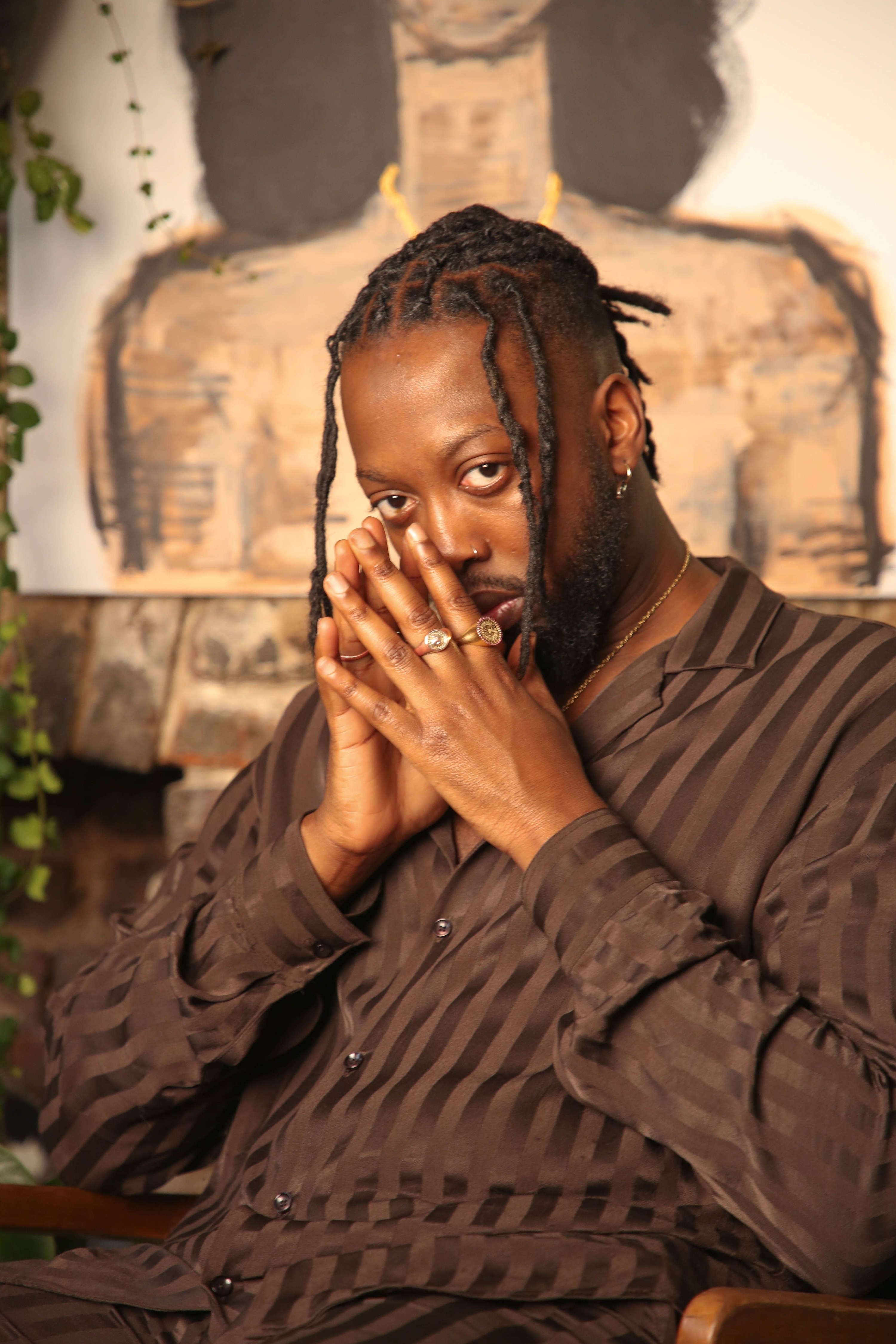 ibrahim kamara posing while sitting with hands together