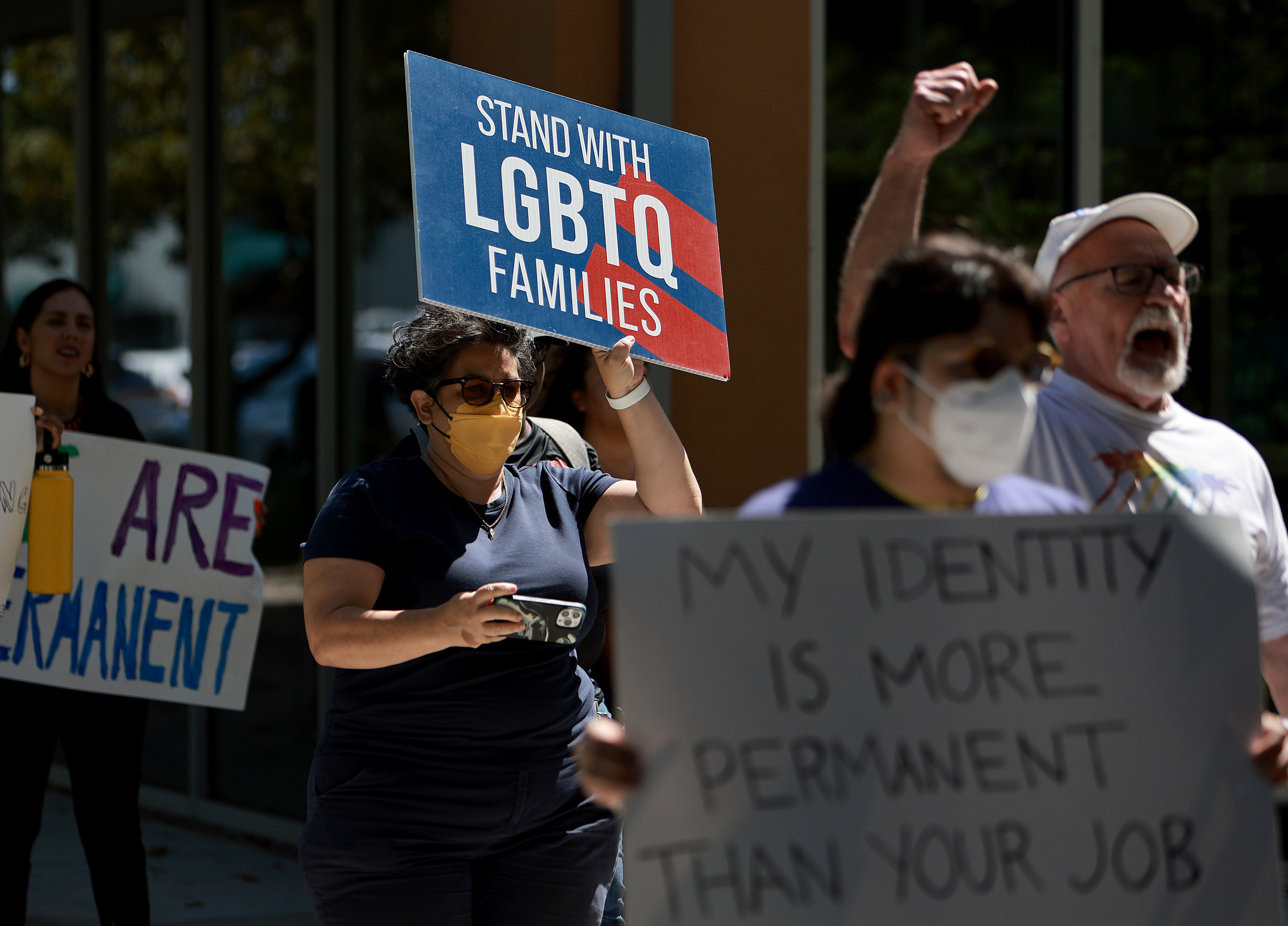 Rallygoers hold signs supporting LGBTQ families