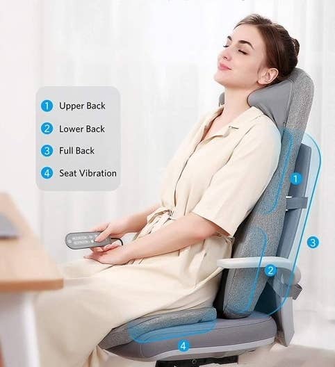 a person sitting at desk using gray massage chair cushion