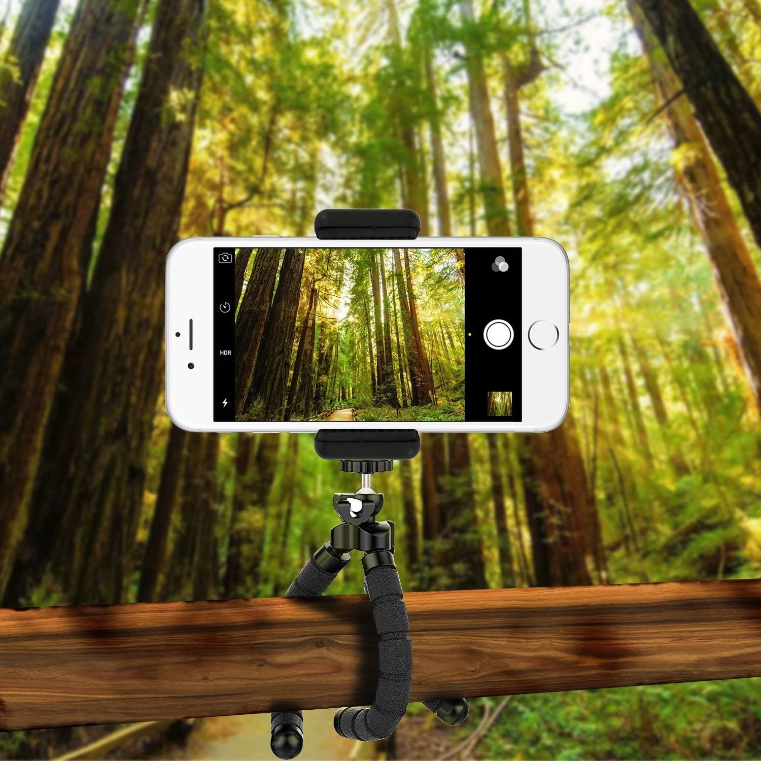 The tripod holding a smartphone, its legs wrapped around a wooden beam