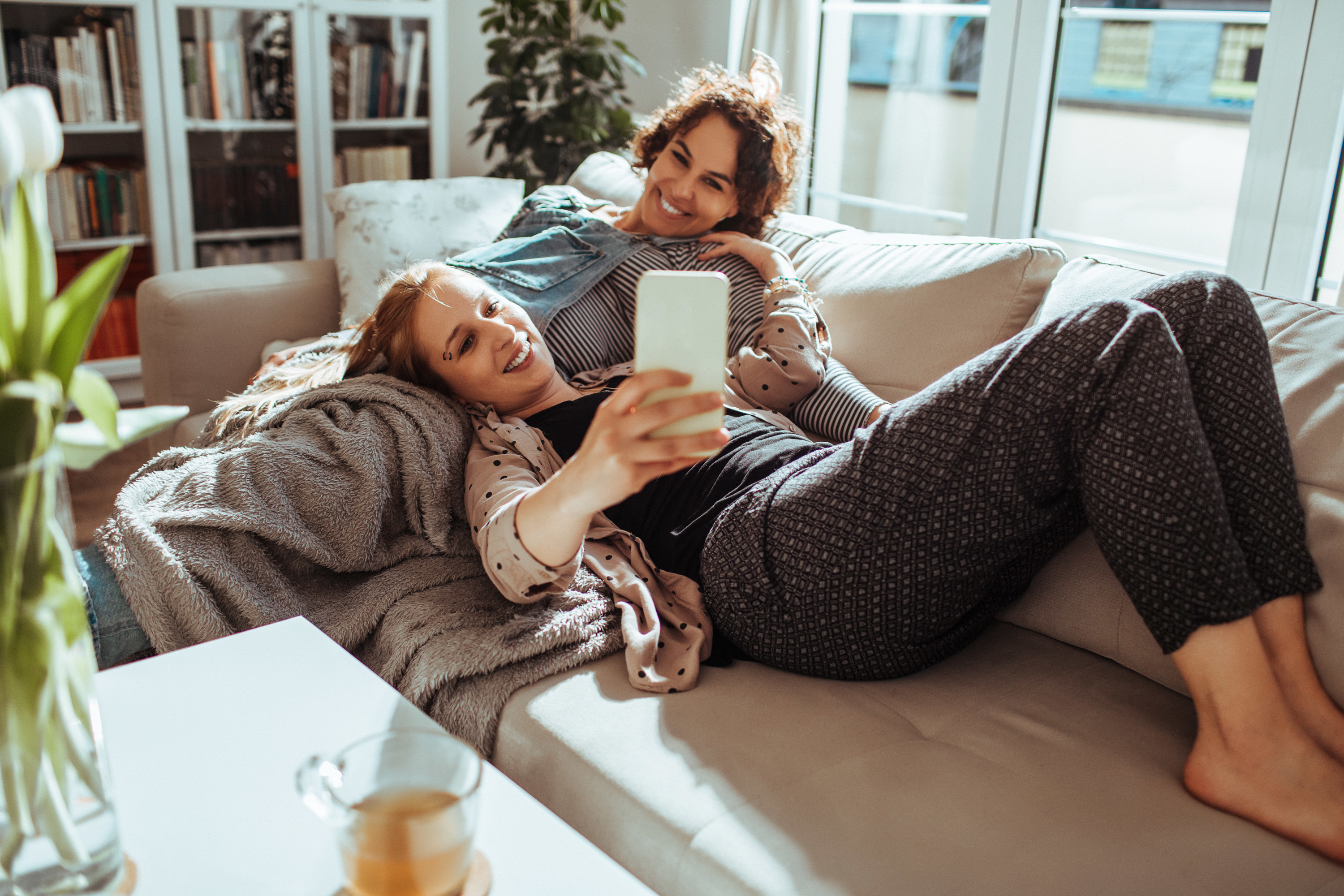 A couple taking pictures together on the couch