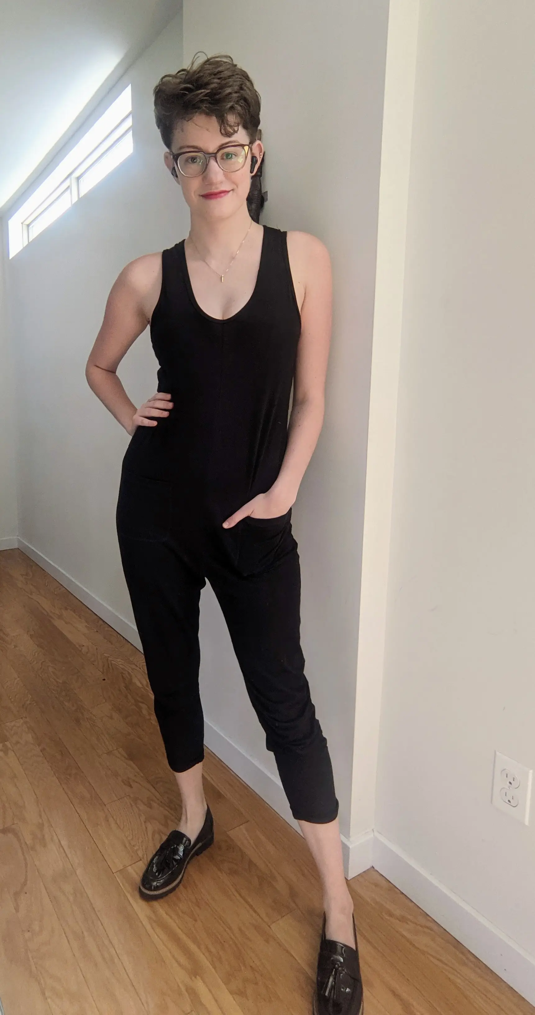 Danielle wearing a black sleeveless jumpsuit