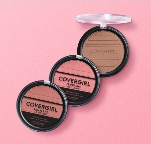 Three black and clear containers of blush on pink background