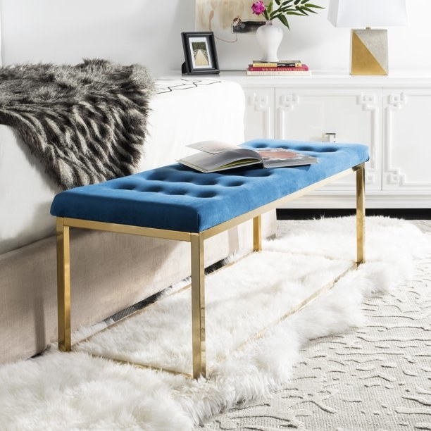 the tufted bench with blue velvet and gold legs