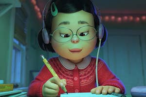 Mei from Turning Red doing her homework at her desk with headphones on