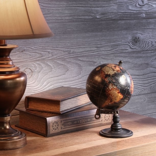 the globe in black and warm colors sitting on a dresser