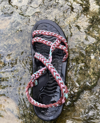 a reviewer photo if the multicolored sandal in a river