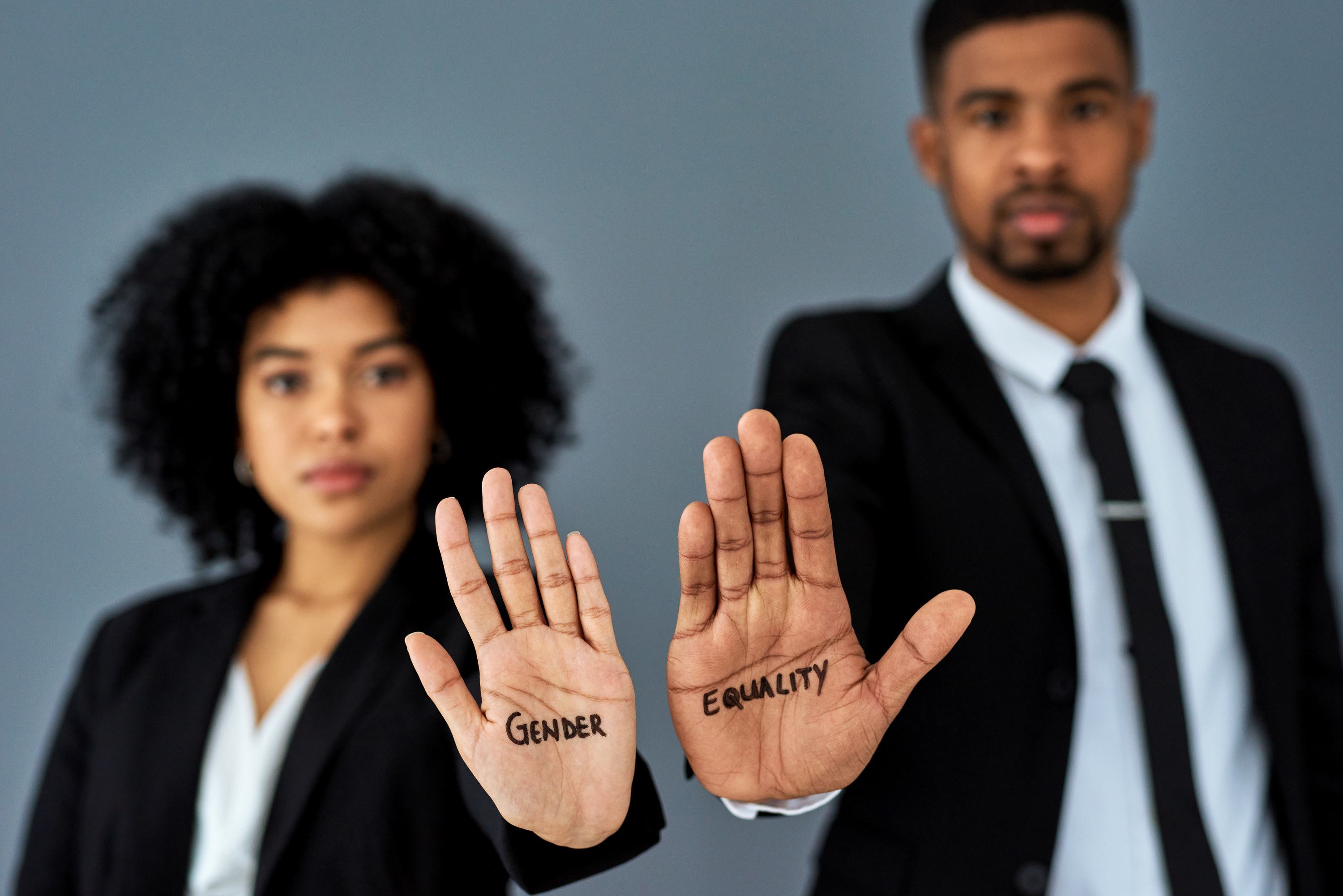 Man and woman with gender equality written on their hands