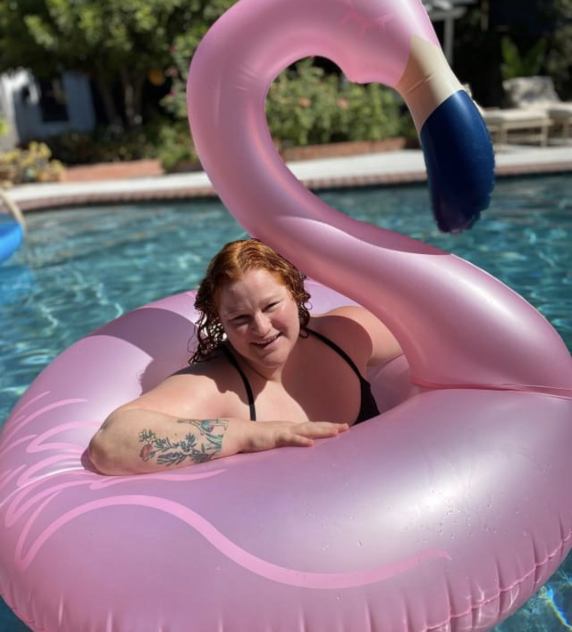 Erica lounging in a pool with a cute flamingo floatie