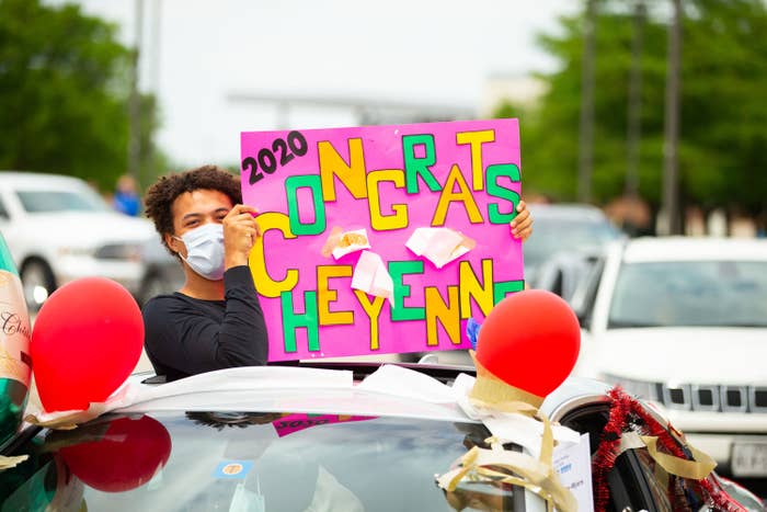 Right: A boy wearing a mask holds up a &quot;Contrats Cheyenne&quot; poster while standing out of a car roof