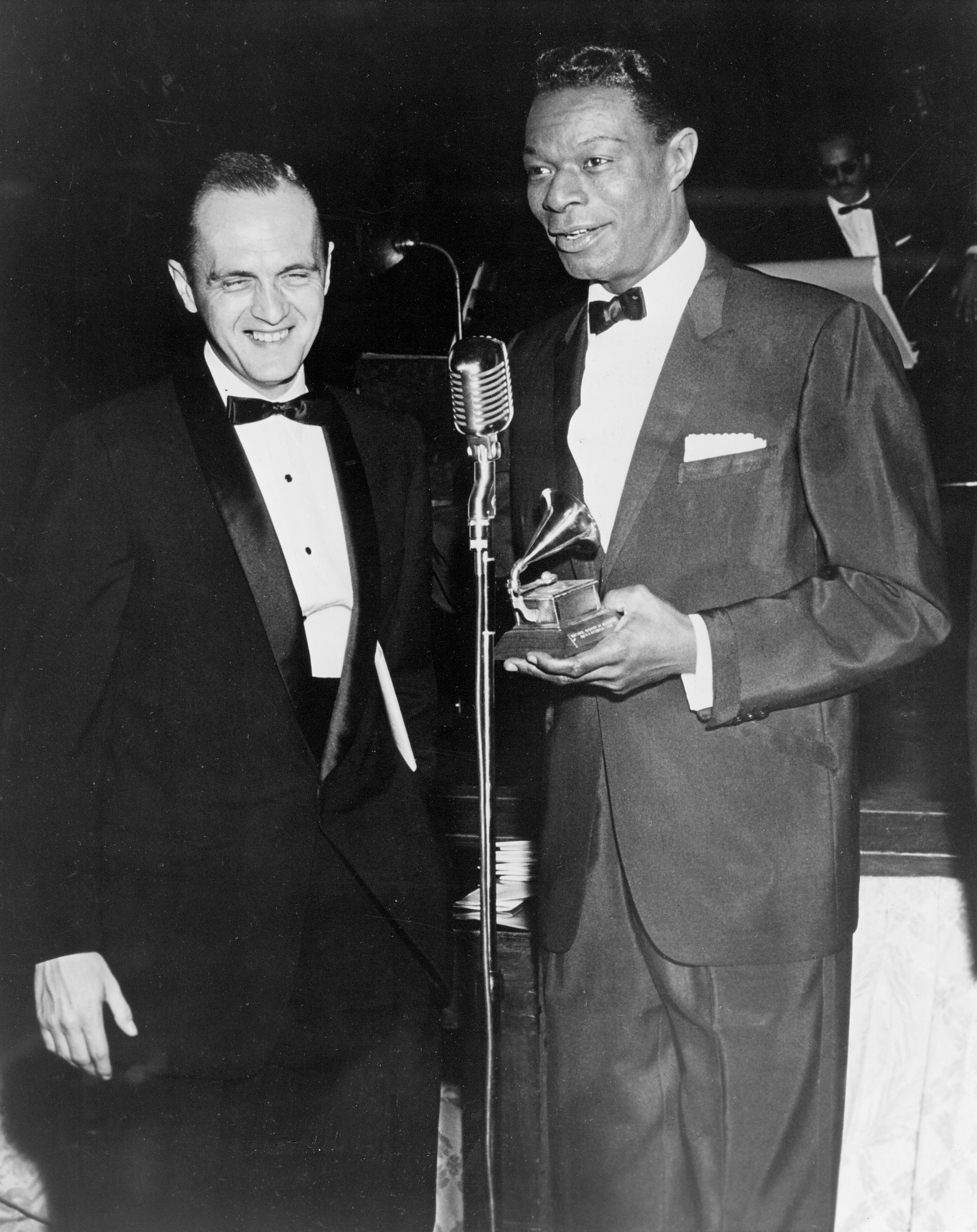 Actor Bob Newhart and singer Nat &quot;King&quot; Cole (holding a Grammy) speak at the microphone during the 1960 Grammy Awards