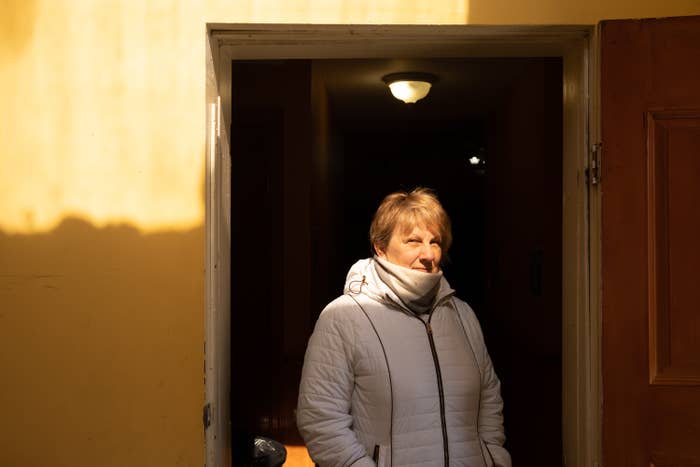 A woman in a puffer jacket stands in a doorway
