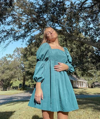 a reviewer wearing the dress in teal