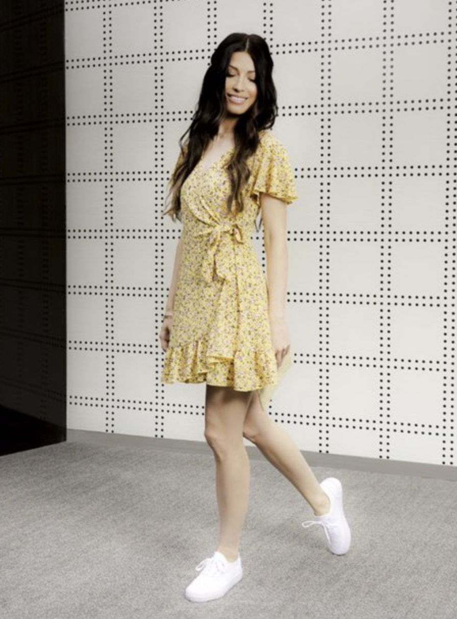 A model wearing a ruffled wrap dress in yellow