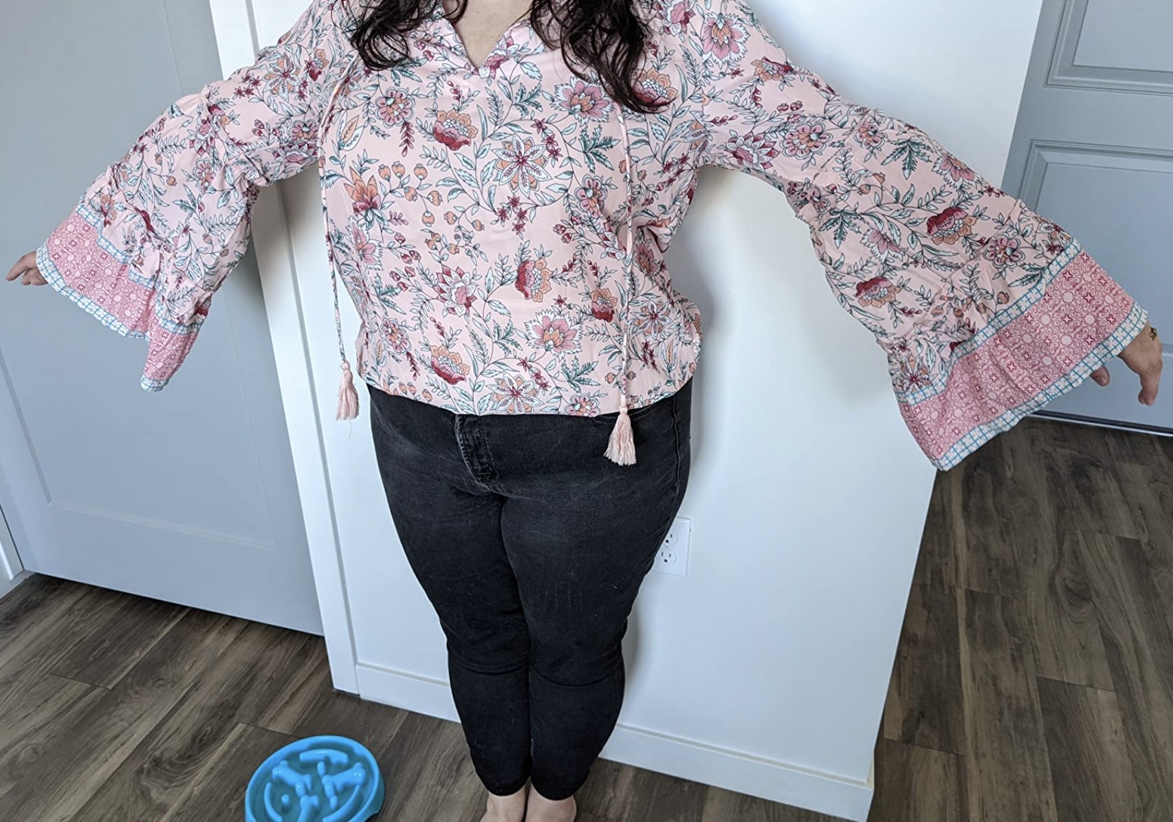 a reviewer wearing the top in pink floral, showing off the sleeves