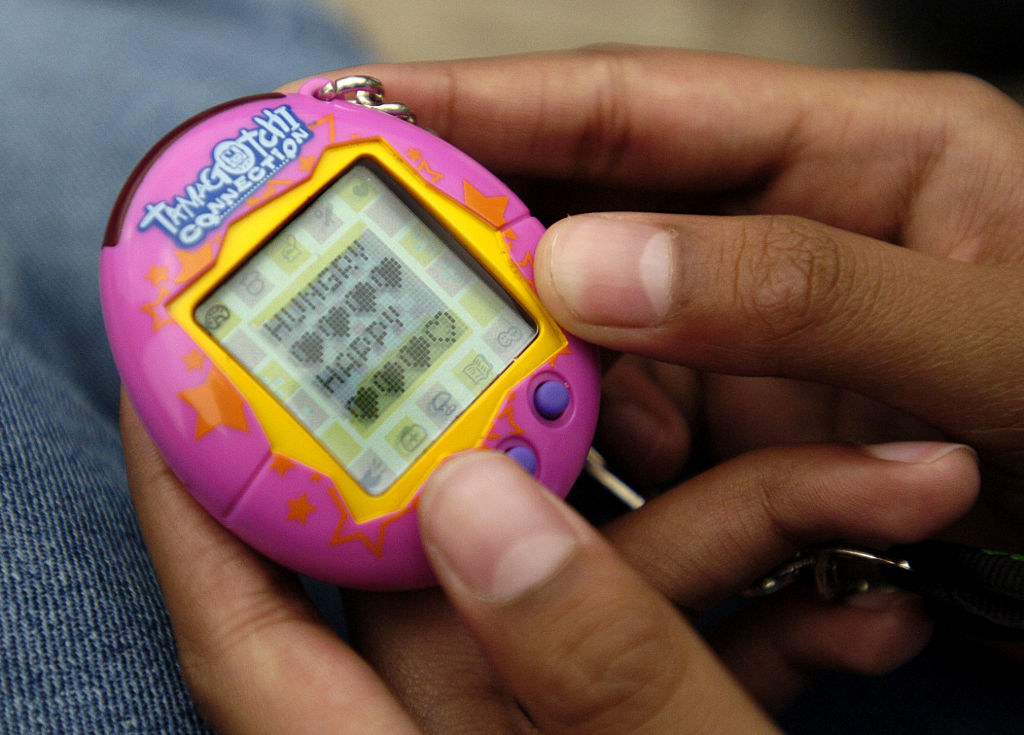 A Tamagotchi that has hearts and the words &quot;hungry&quot; and &quot;happy&quot; on its screen
