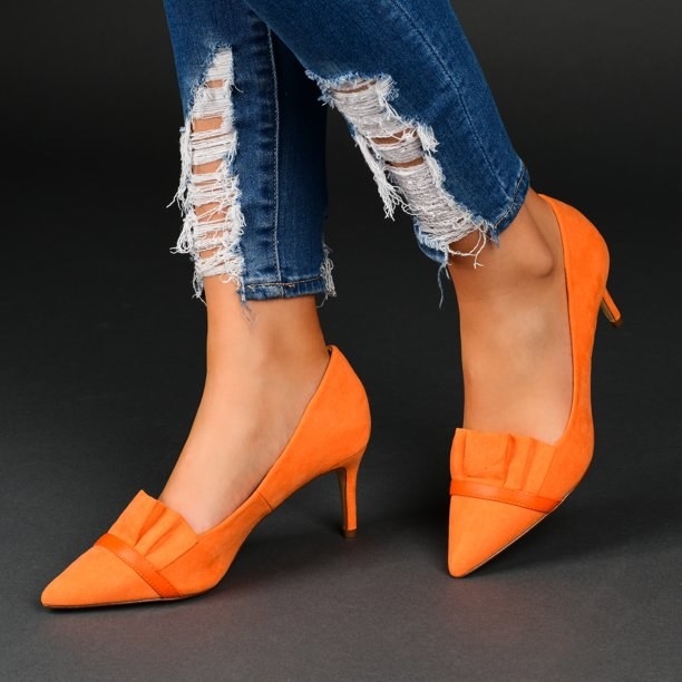 model wearing the shoes in orange