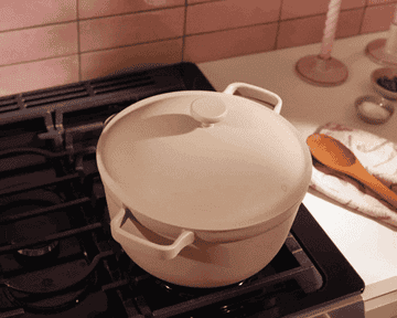 A Gif of a person lifting the lid off the pot to reveal a cauliflower