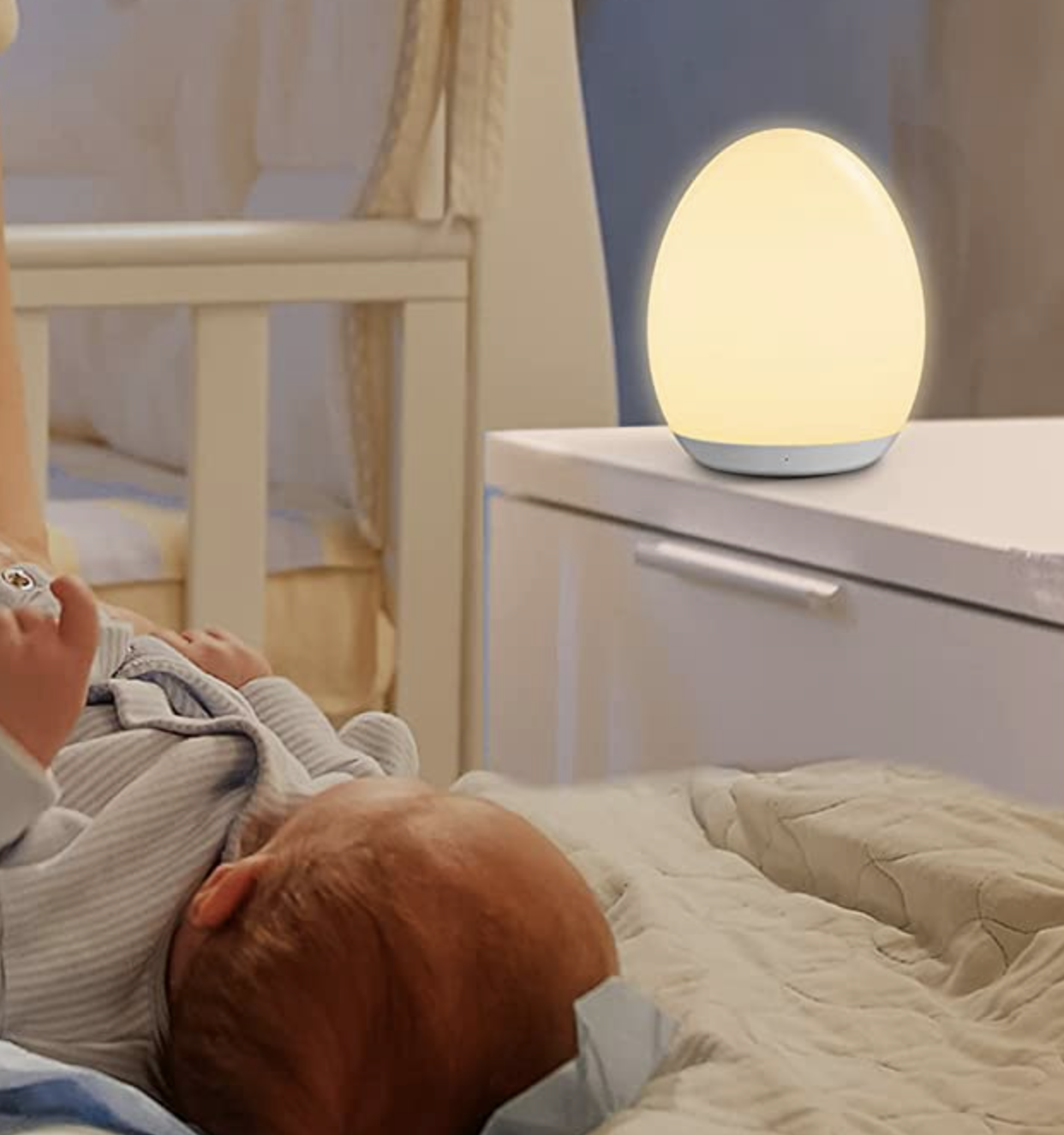 A baby sleeping next to the lamp