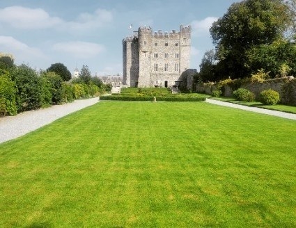 A view of the castle grounds, which includes a long manicured grassy lawn and garden with hedges