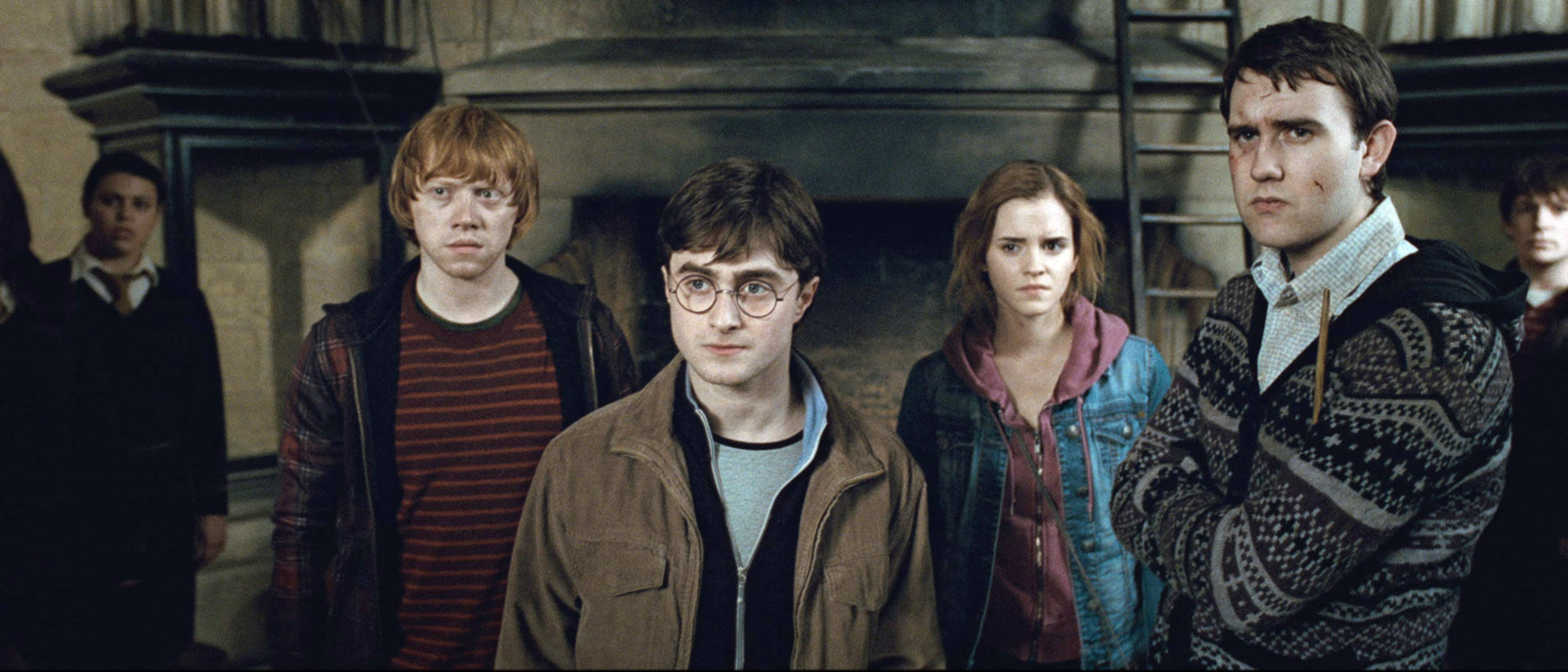 Harry standing Ron, Hermione, Neville, and other students in a scene from Harry Potter