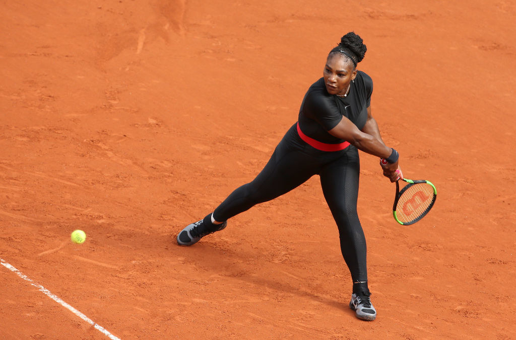Serena Williams playing tennis in a black catsuit