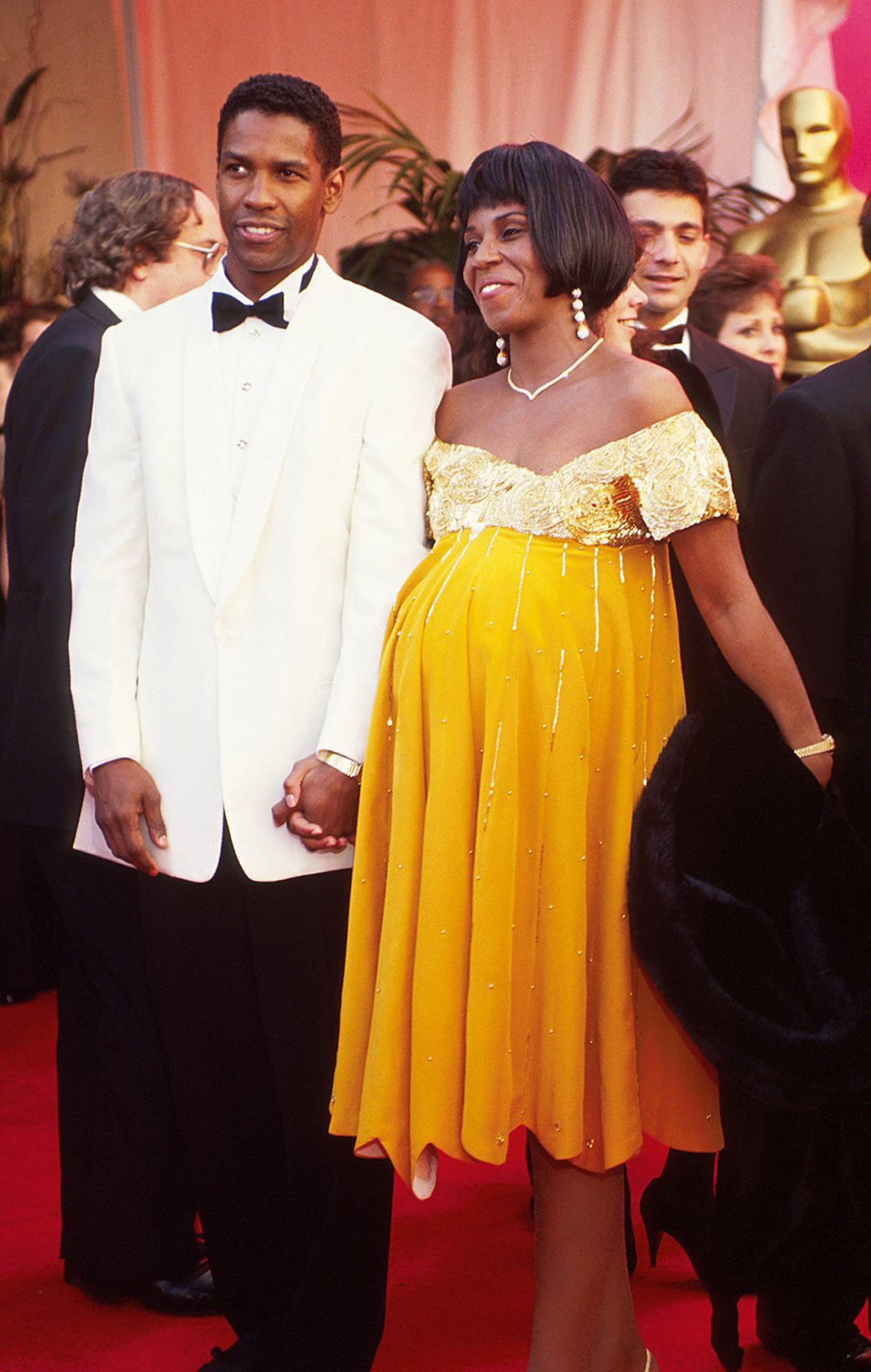 Washington in a white tuxedo jacket and his wife wearing a yellow dress