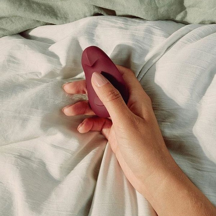 Model holding red palm-sized vibrator