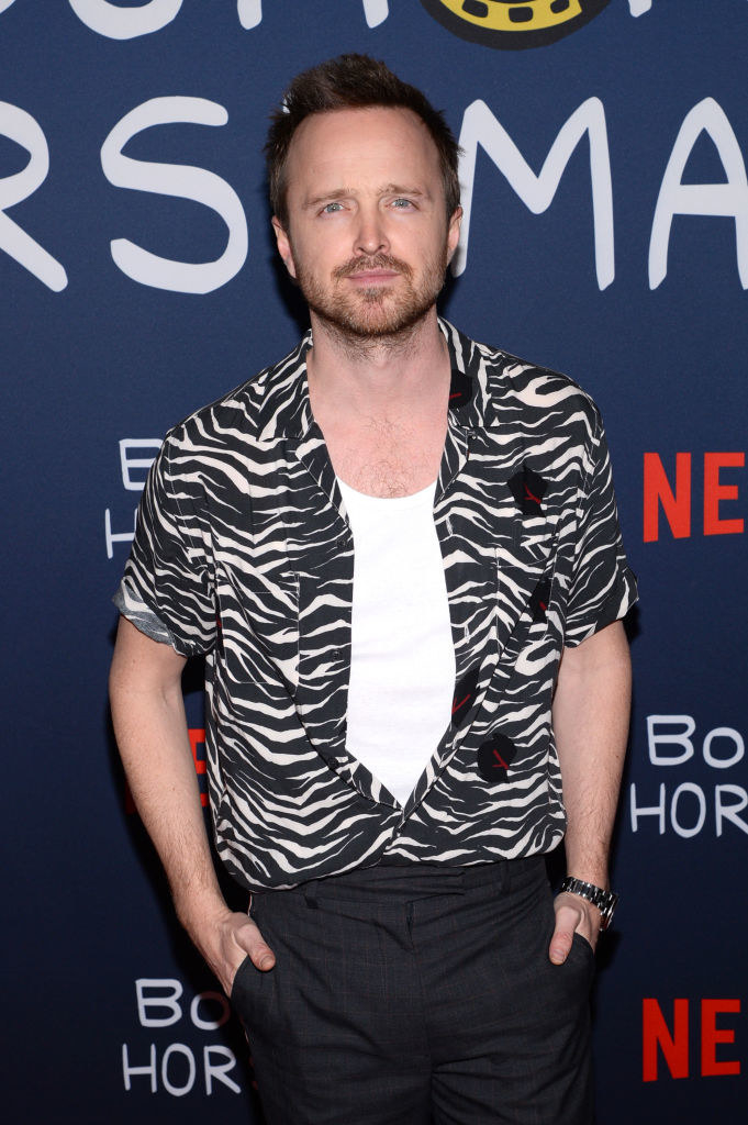 Aaron on a red carpet with a button down opened to reveal a T-shirt underneath