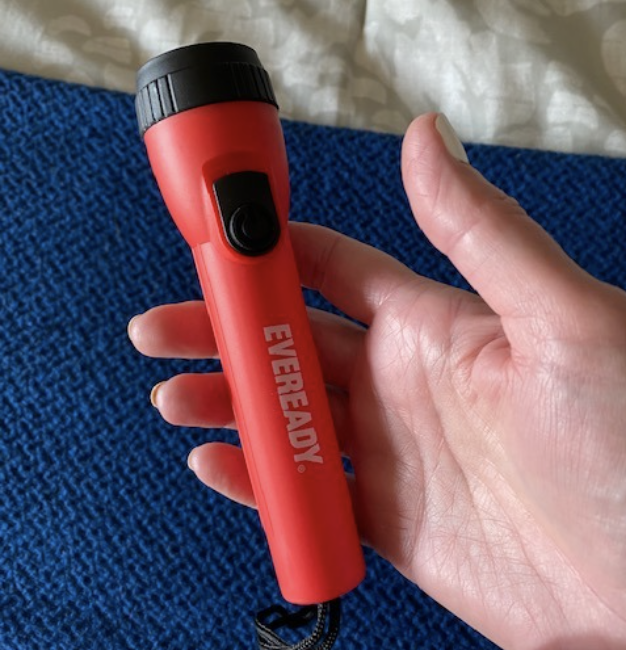 a reviewer photo of a hand holding the red flashlight