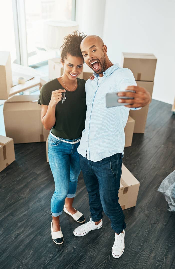A young couple takes a selfie in their new home