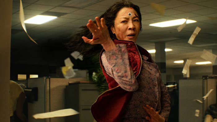 Michelle Yeoh in a martial arts pose, wearing a googly eye on her forehead