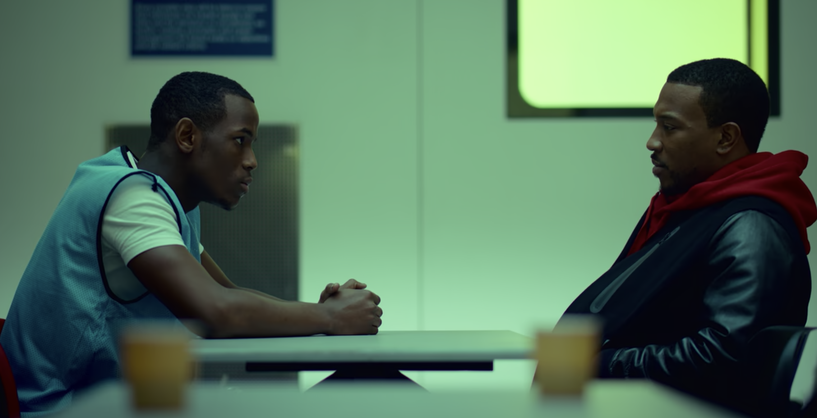 Jamie and Dushane speaking speaking across a visitor&#x27;s table in jail