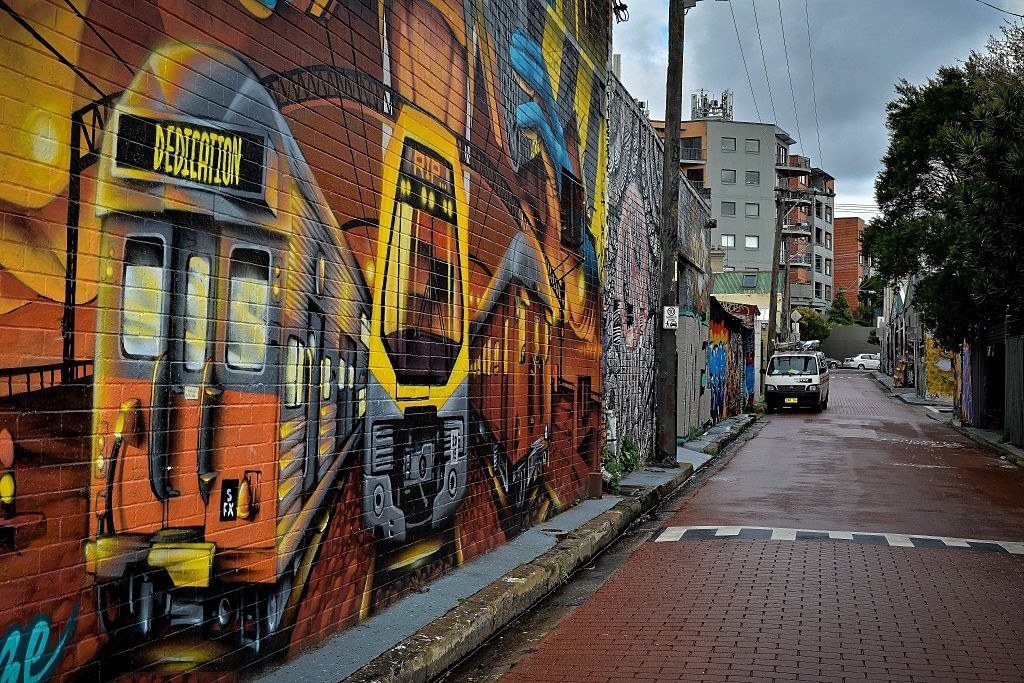 graffiti art along a brick wall in an alley