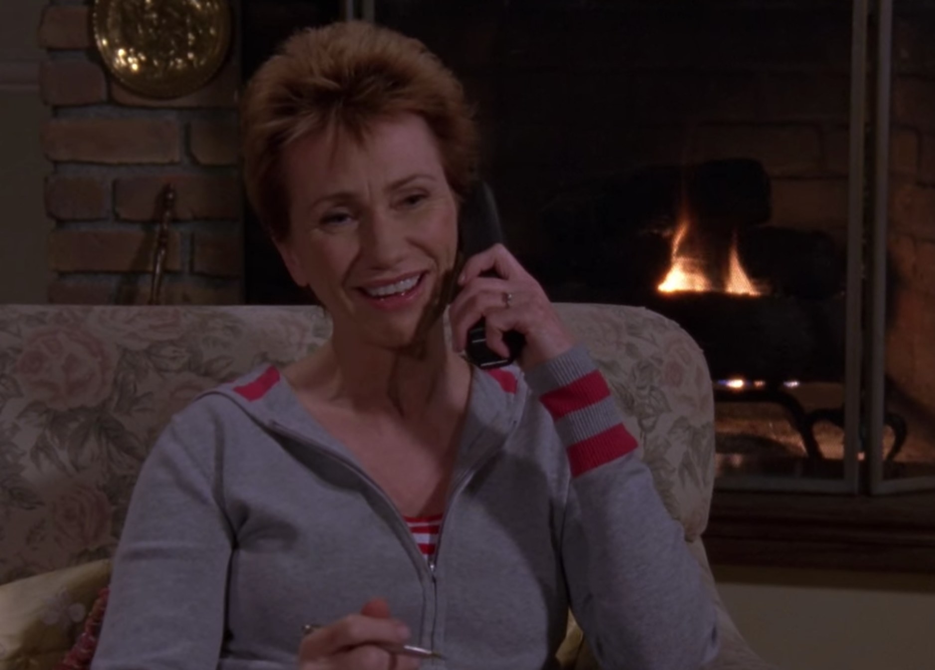 Mia in front of a fireplace on the phone in Gilmore Girls
