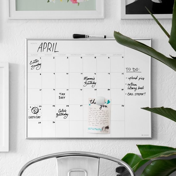 Dry erase board calendar mounted on white wall