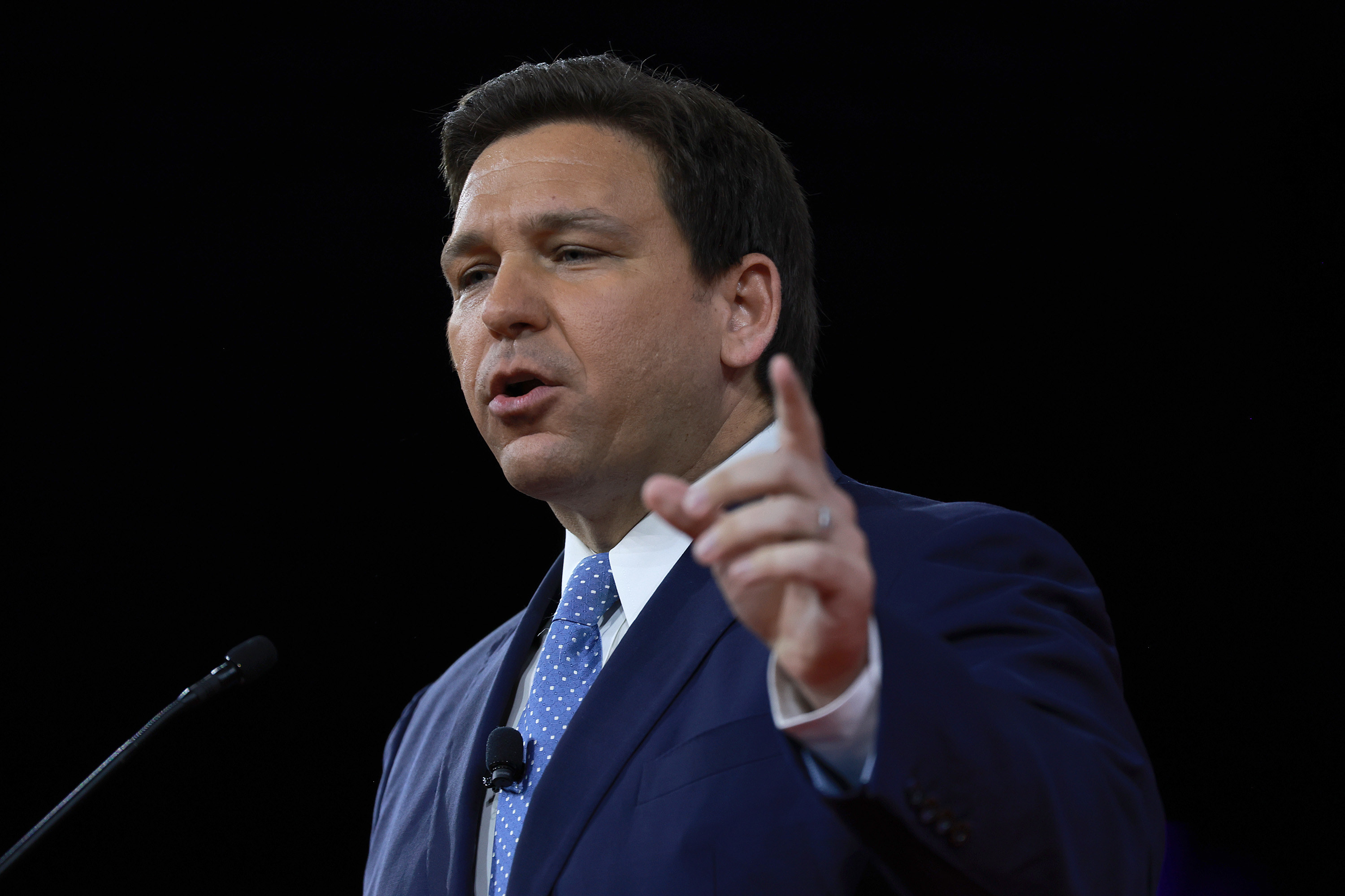 Governor Ron DeSantis speaks in front of a microphone