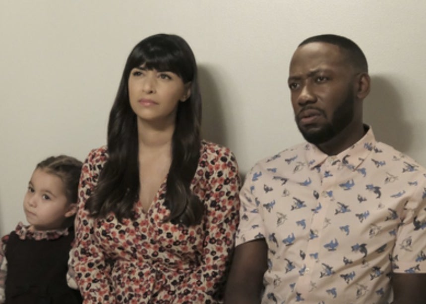 A small girl, woman, and man, sit on a bench. They all seem confused.