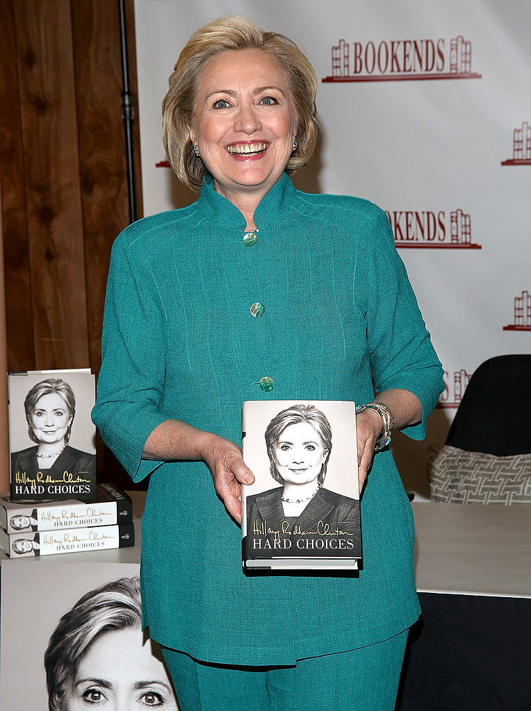 Hillary Clinton holding up her book
