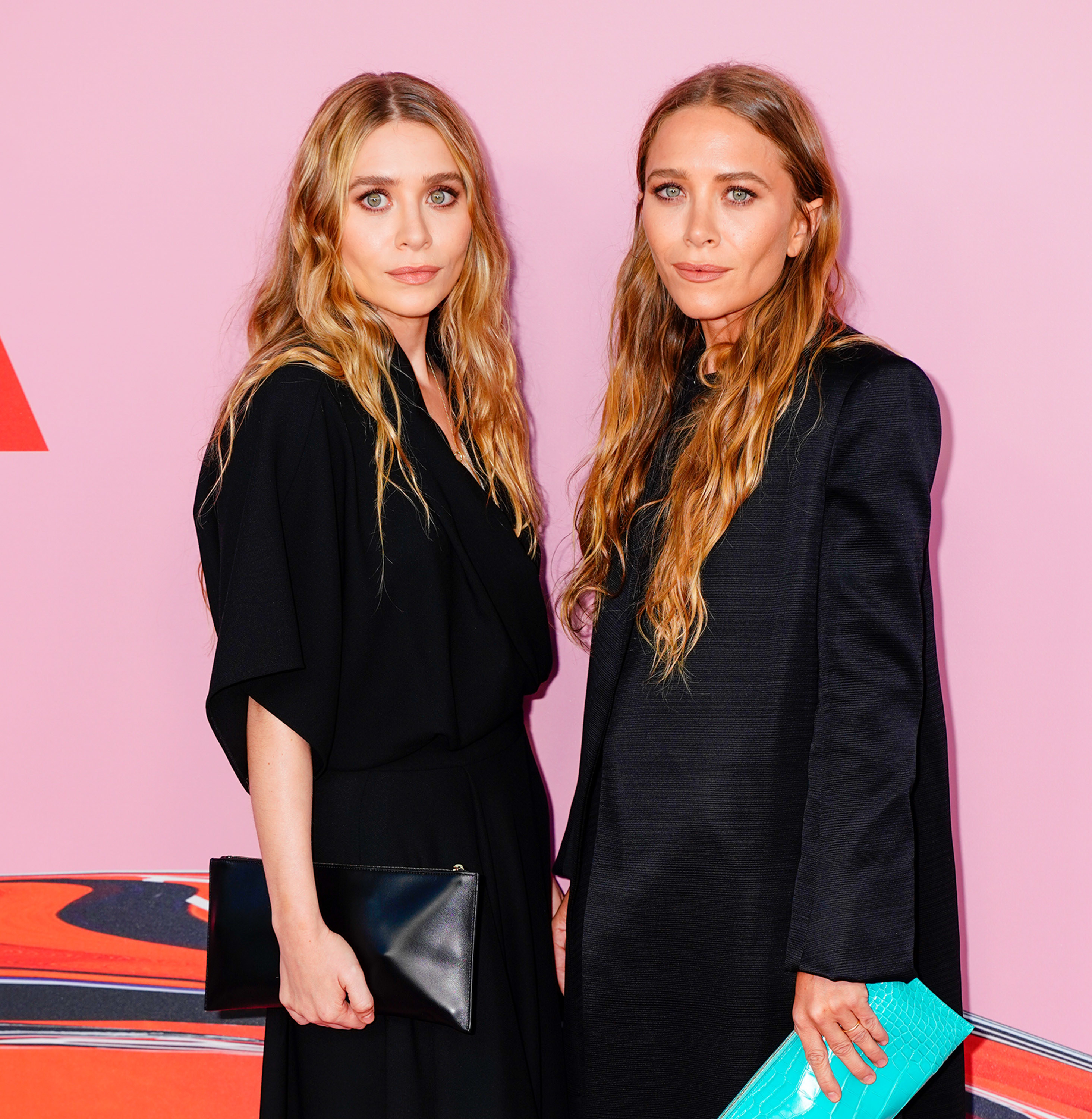 Mary-Kate and Ashley in all black with their signature wavy hair at an event