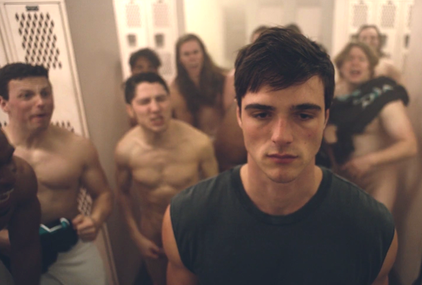 Nate surrounded by half-naked men in a locker room