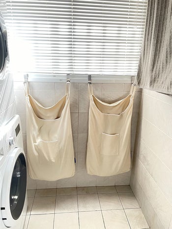 reviewer image of two wenko over-the-door laundry bags hanging in a laundry room