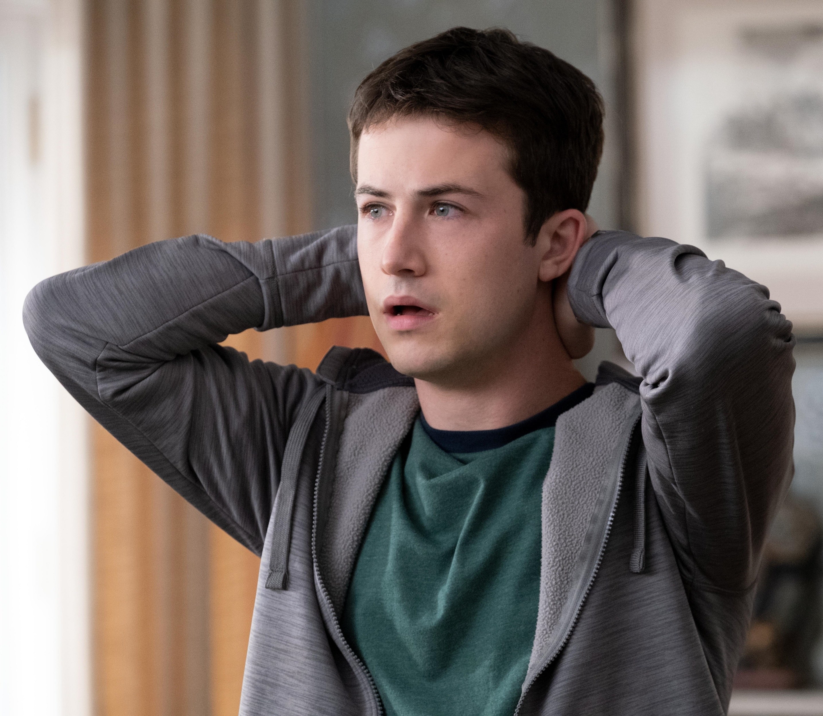 Dylan Minnette holds his hands together at the back of his neck