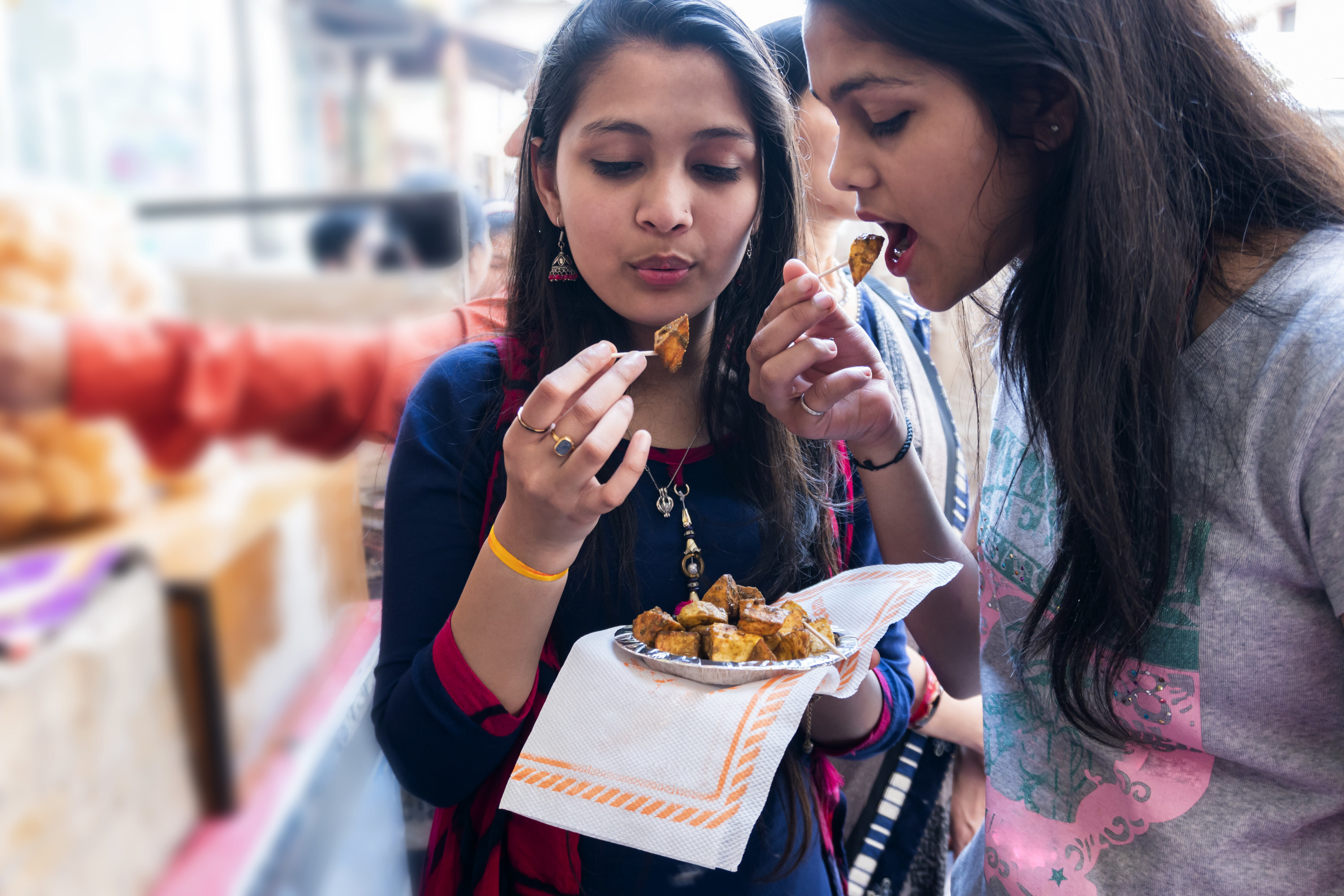 Two girls eating aloo chaat